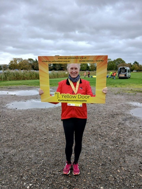 Mayor holding a yellow door sign on the fun run